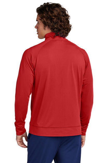 A person with curly brown hair is shown from the back, wearing a Creative Kids Learning Center Sport-Tek Sport-Wick Stretch Full-Zip Cadet Jacket ST857 and dark blue pants, standing against a plain white background.