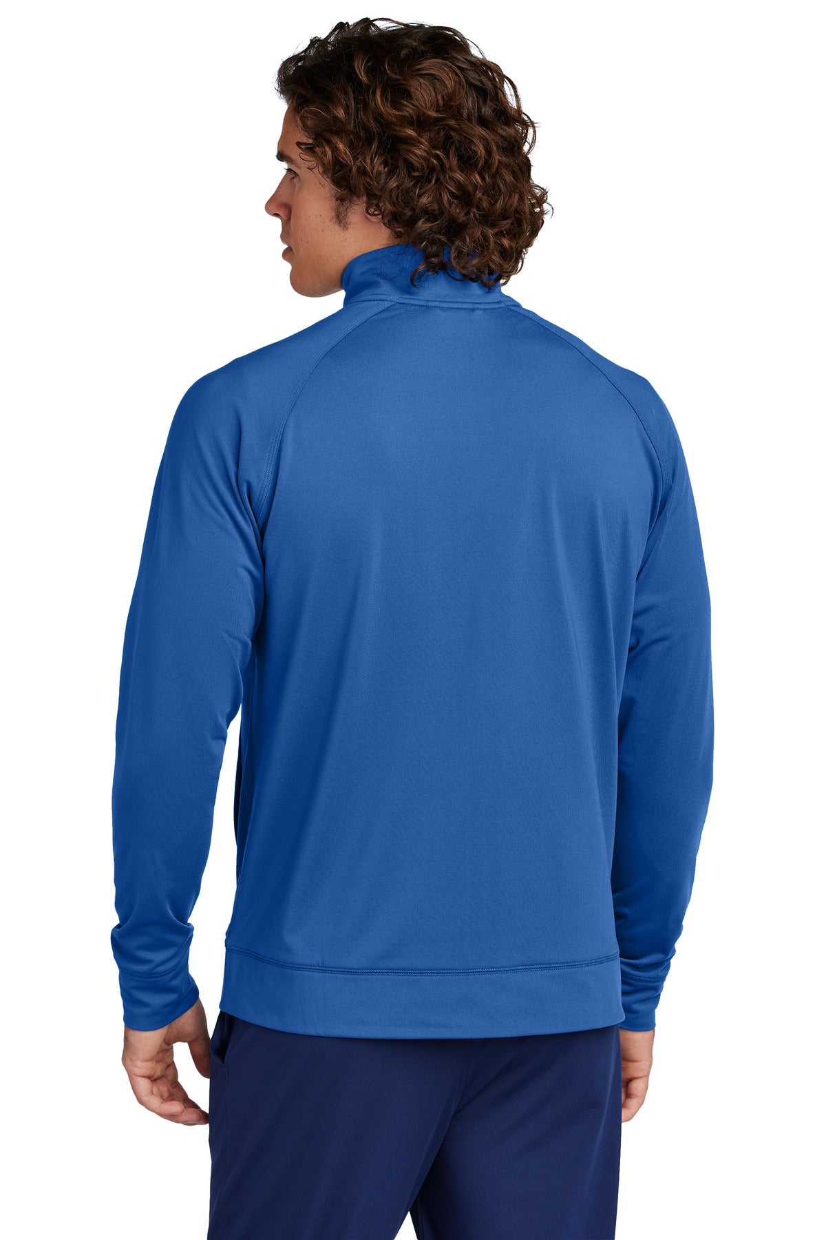 A man with curly brown hair is shown from the back wearing the Creative Kids Learning Center CKLC Sport-Tek Sport-Wick Stretch Full-Zip Cadet Jacket ST857 and dark blue pants, standing against a plain white background.
