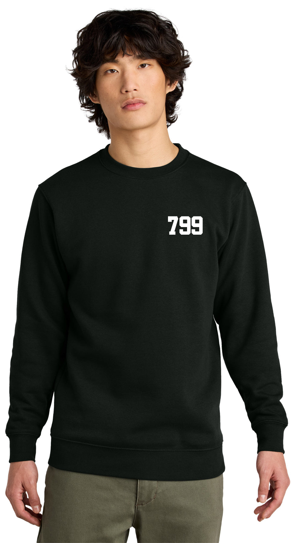 A young person with wavy hair wears the black LKOT Crewneck Sweatshirt — Adult, featuring a white 799 on the left chest, against a plain white background.